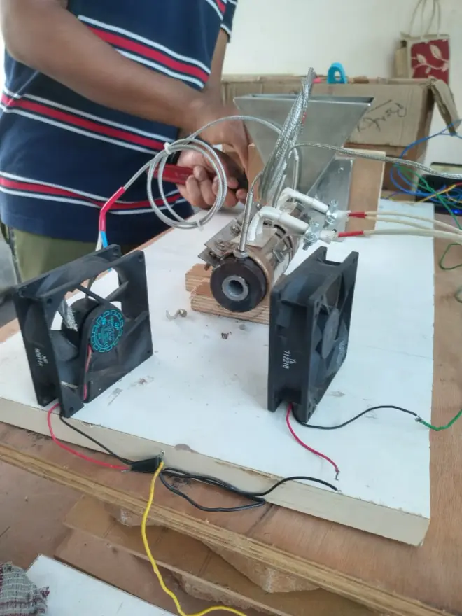 Close-up of the barrel, screw, and nozzle with cooling fans, mid-assembly.
