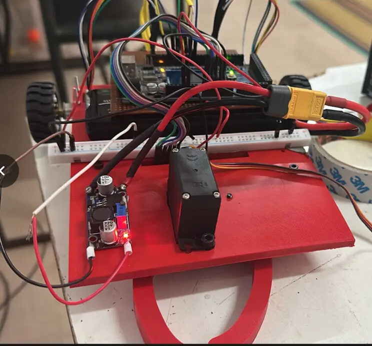 Trident Version 2: the printed robot during wiring, showing the 3D-printed chassis, caging gripper servo, and power circuitry.